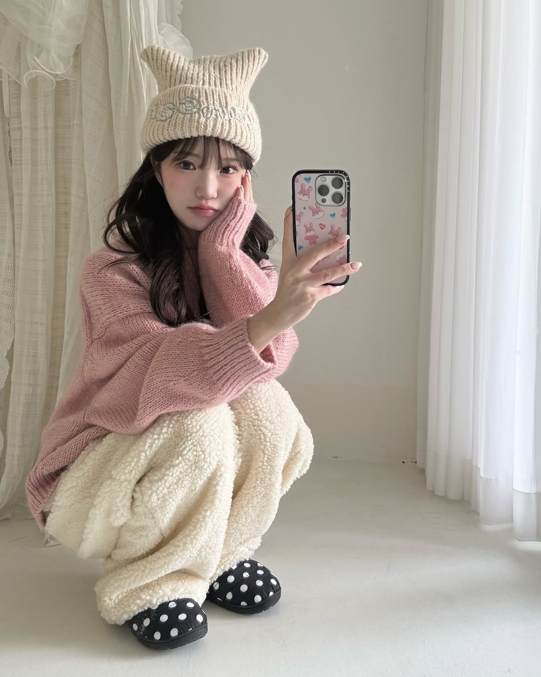 Photo shared by 세니 on December 12, 2025 tagging @casetify, and @casetify_kr. May be an image of hat, sleepwear, bath robe, knit, fur, parka and text.