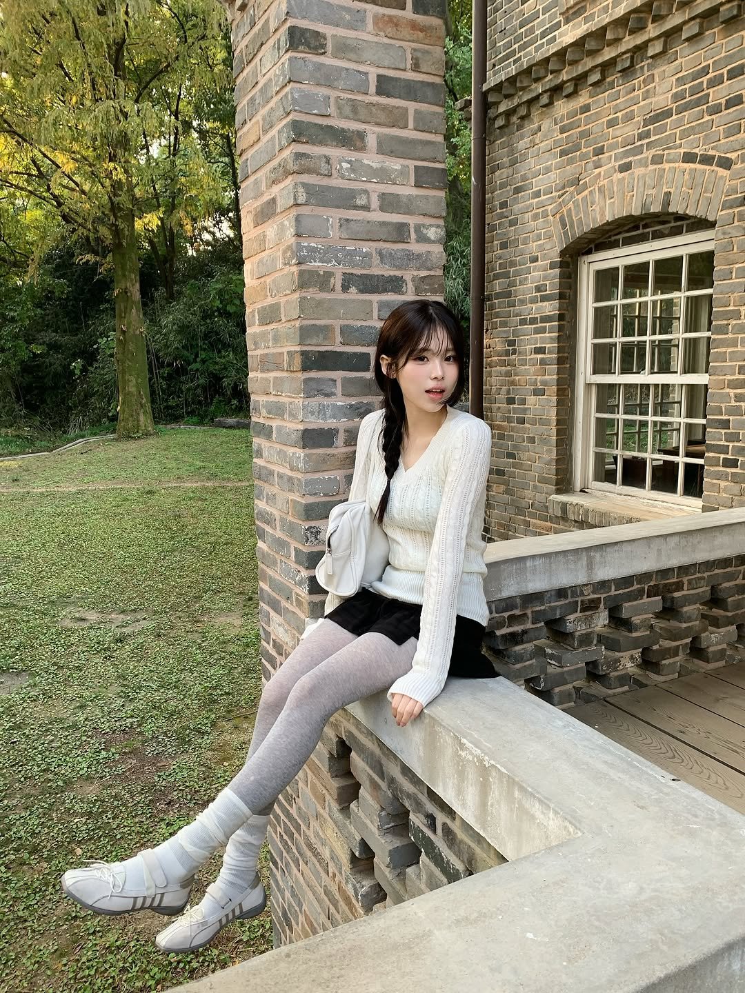 Photo shared by 안민서 on November 13, 2025 tagging @rockfish_official. May be an image of miniskirt, tights, fishnet stockings, brick wall and text.