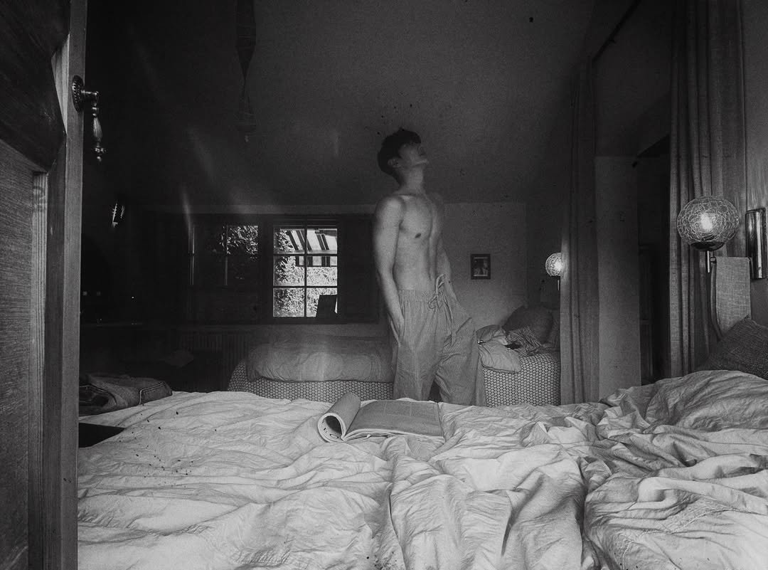 Photo by 정선혁 Seon Hyeok on August 03, 2025. May be a black-and-white image of 1 person, cigarette, bed, bedroom and text.