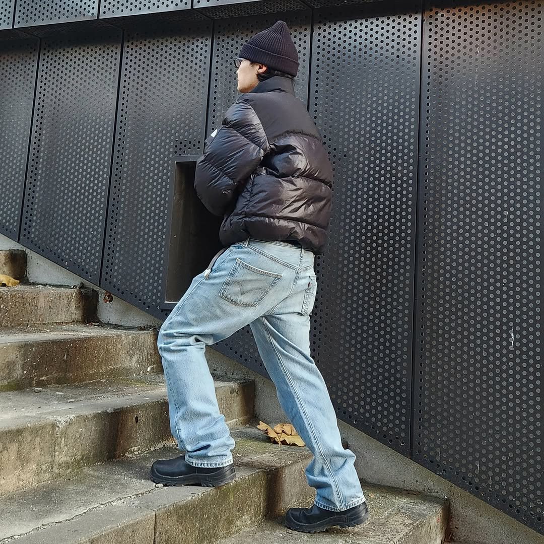 Photo shared by 서울데님 on December 03, 2025 tagging @seoul__denim. May be an image of standing, goosedown coat, duffle coat, parka and text.