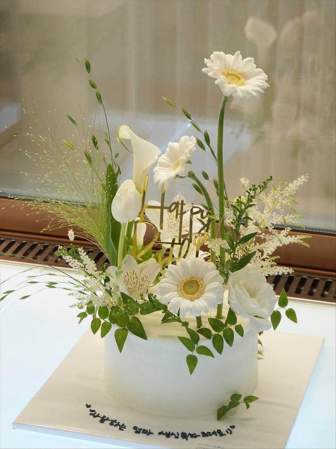 Photo shared by 세라케이크/어버이날케이크/크리스마스케이크/운정케이크/운정카페/파주케이크/플라워케이크 on September 21, 2025 tagging @sera_cake_. May be an image of flower arrangement, white lily, prairie gentian, amaranth, baby's-breath, ivy, carnation, lily and text.