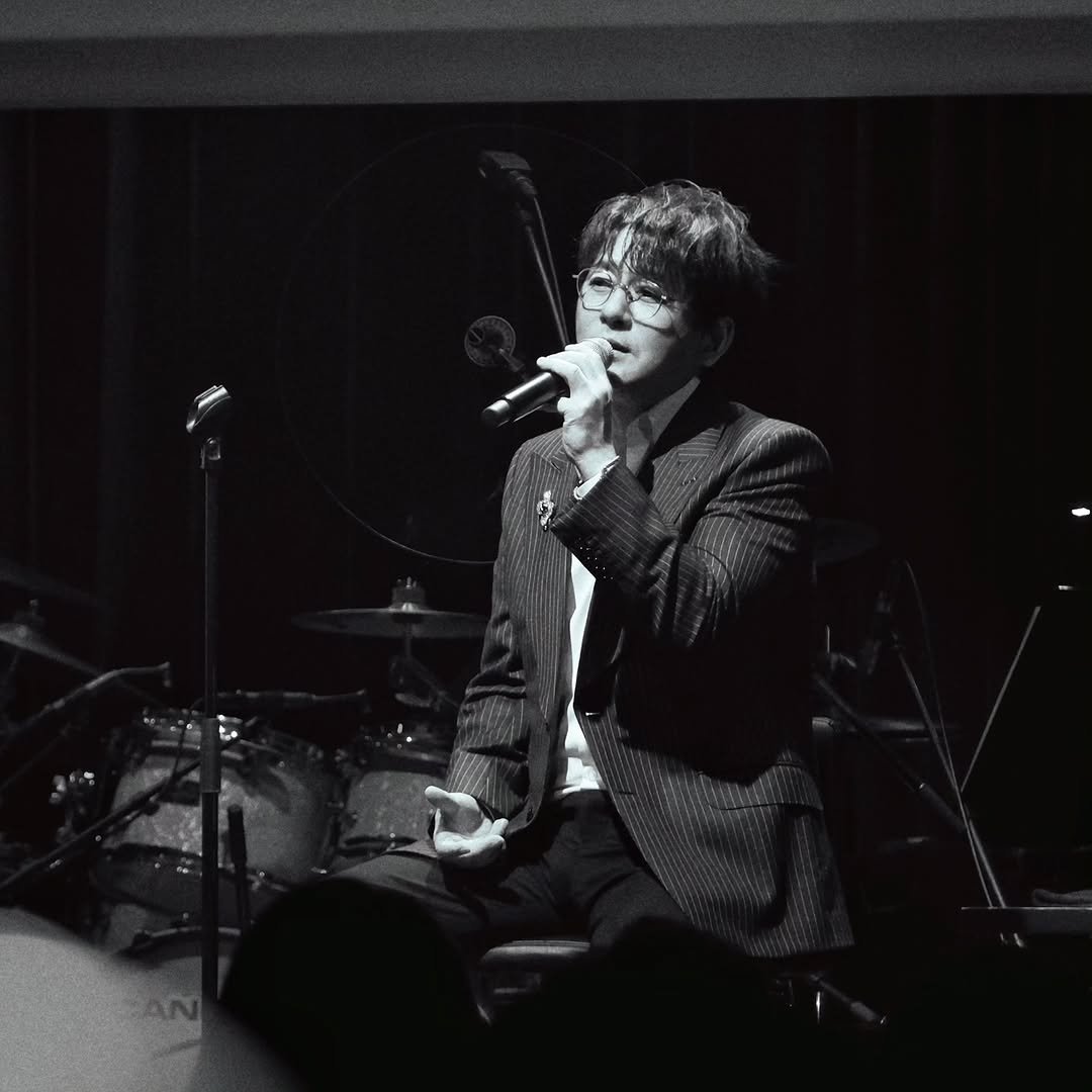 Photo by 신승훈 on February 09, 2026. May be a black-and-white image of one or more people, bangs, microphone, concert and text.