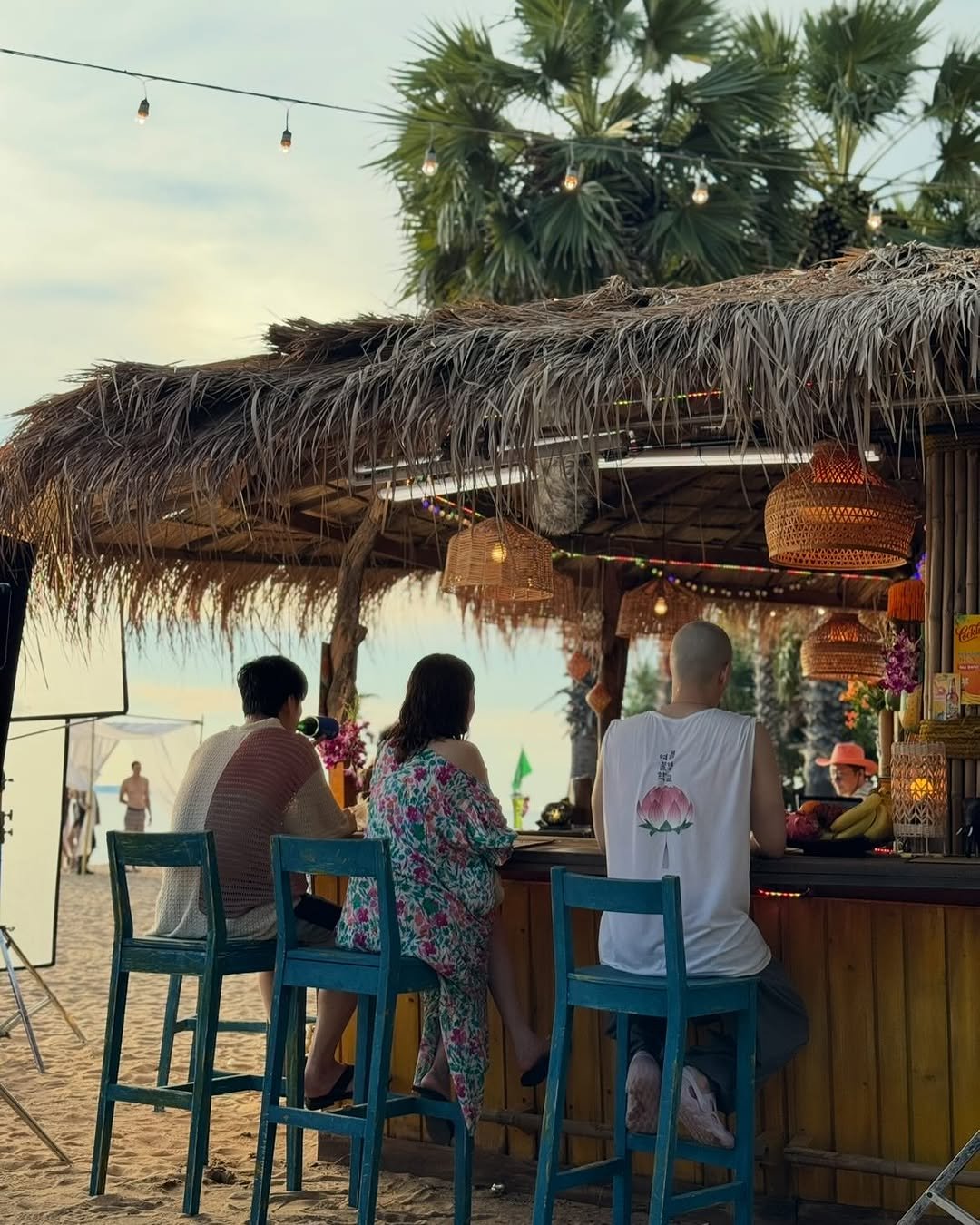 Photo by shh daily on October 29, 2025. May be an image of one or more people, drink, parasol, umbrella, outdoors, palm trees, cabana and text.