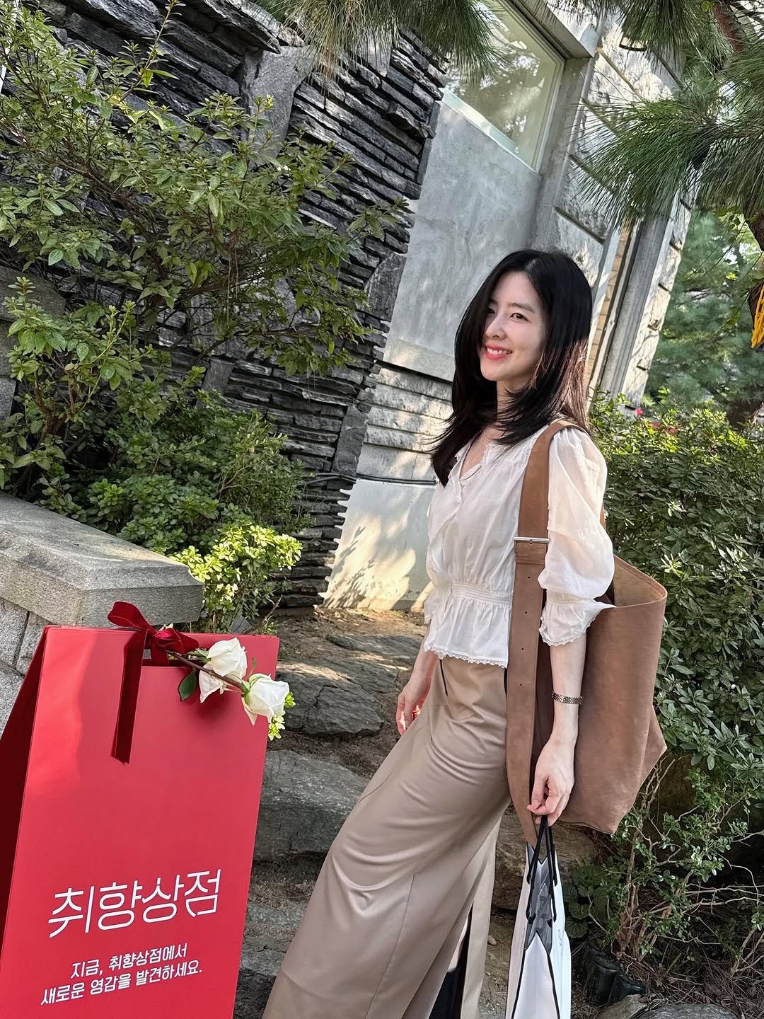 Photo shared by Eunbi Kim on September 26, 2025 tagging @sk_stoa. May be an image of 1 person, purse, white lily and text that says 'yue ក្មពចាទ Xo မိပ 취향상점 지금, ะ 취향상점에서 새로준협감을발건하세요. 새로운 열감을 지금,취황삼점에서 발견하세요.'.