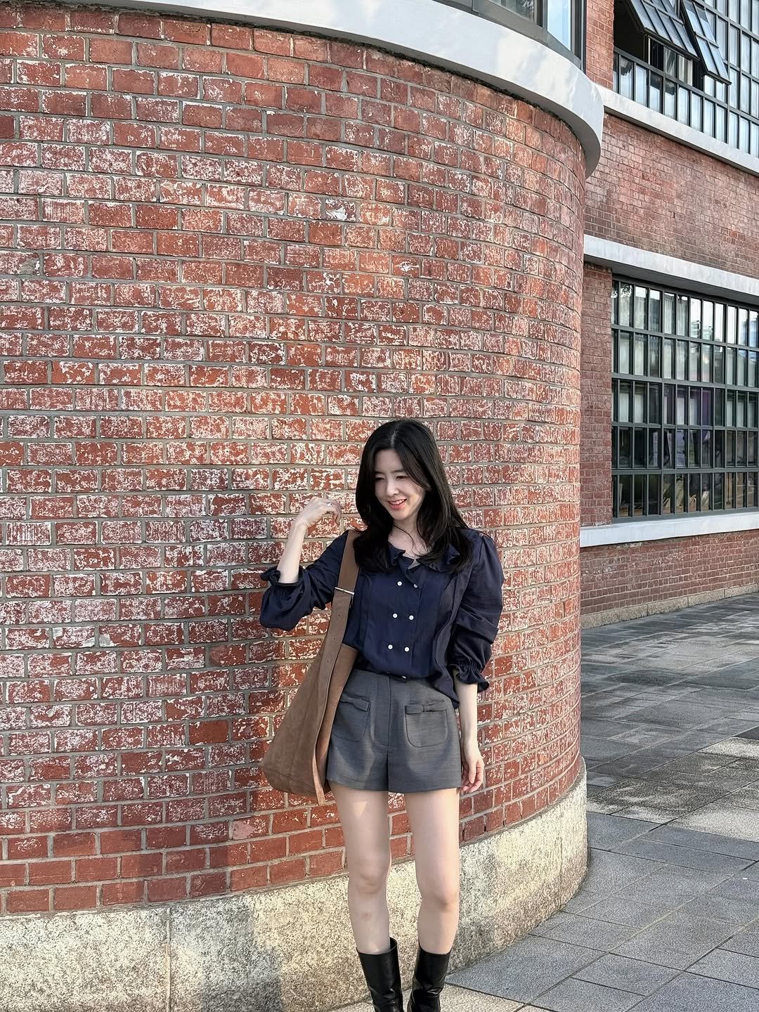 Photo by Eunbi Kim on September 21, 2025. May be an image of 1 person, duffle coat, boots, miniskirt, brick wall and text.