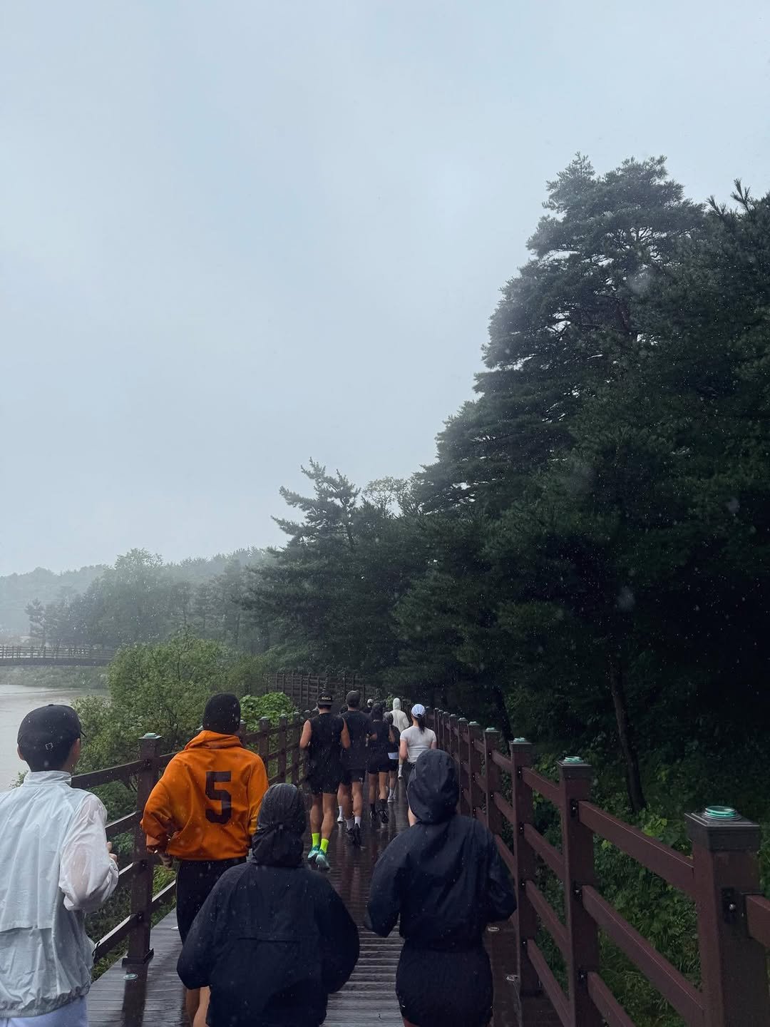 Photo shared by 이승호 on September 22, 2025 tagging @5kmman. May be an image of 7 people, raincoat, fog, park and text.