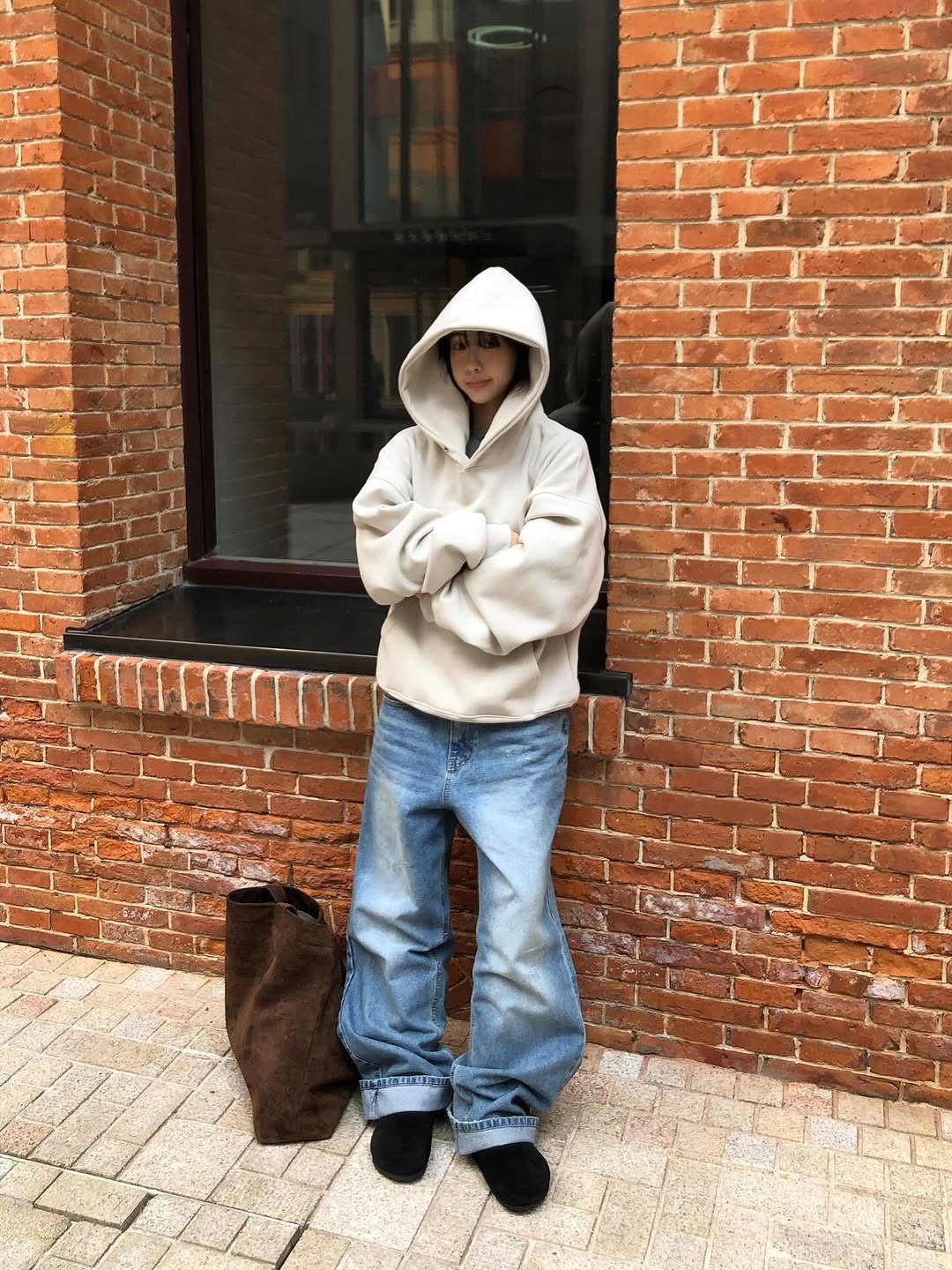 Photo by 진 / Jin on December 10, 2025. May be an image of duffle coat, overcoat, fleece, raincoat, sweatshirt, parka, bath robe, cloak, brick wall and text.
