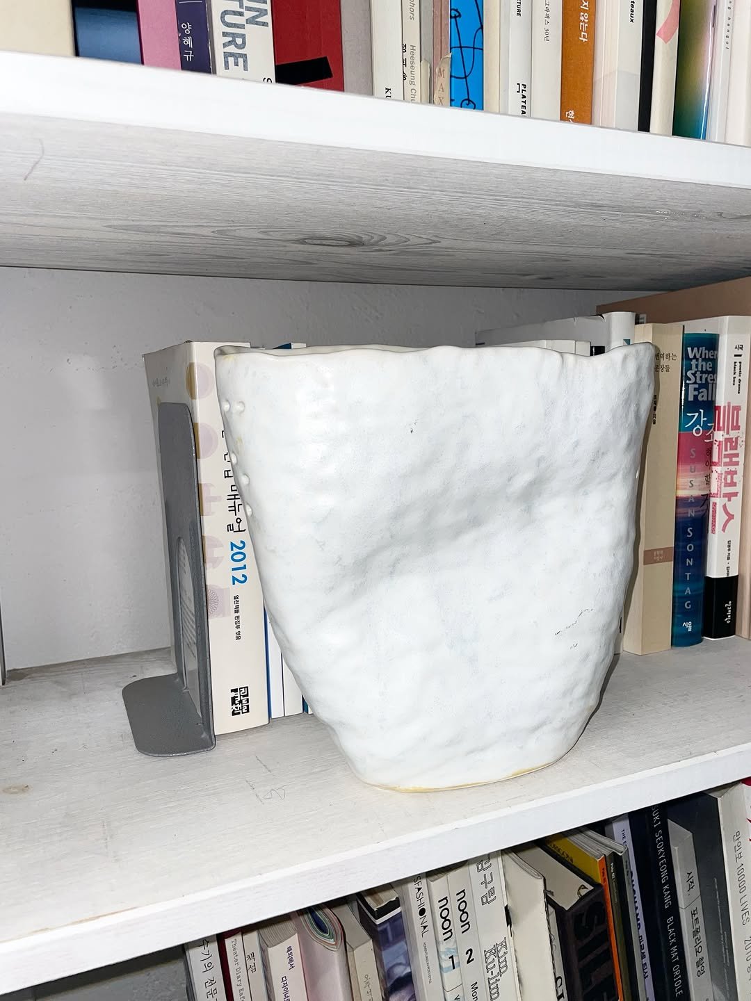 Photo shared by 홍소이 Soi Hong on February 09, 2026 tagging @nonemptysite, and @soicup. May be an image of book, shelf and pottery.