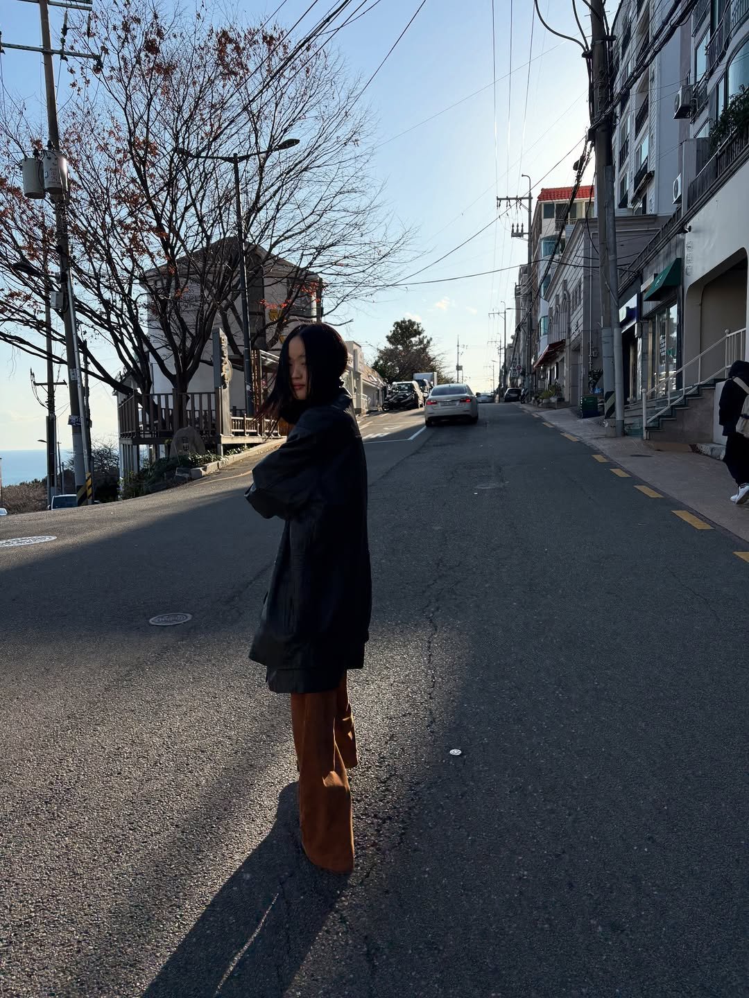 Photo by 아방 on December 08, 2025. May be an image of duffle coat, overcoat, parka, street, road and text.