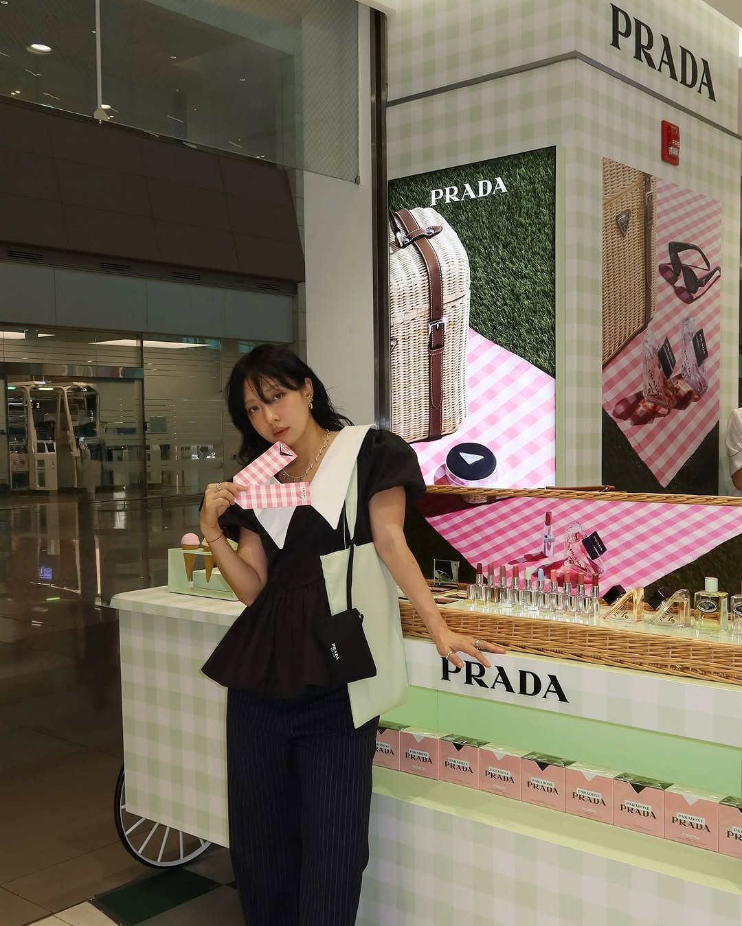 Photo shared by soso🫧 Kim dayoung on July 30, 2025 tagging @pradabeauty. May be an image of 1 person, display case and text.