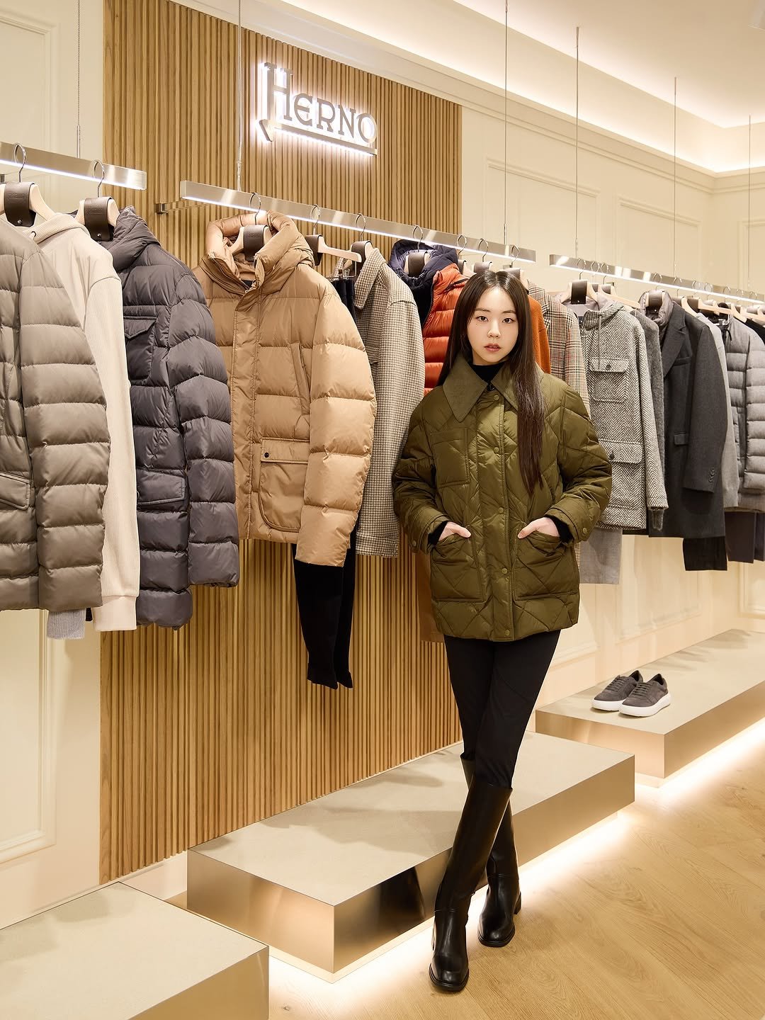 Photo shared by 안소희 on October 25, 2025 tagging @herno. May be an image of sable coat, goosedown coat, parka, rack, display case, jacket and text.