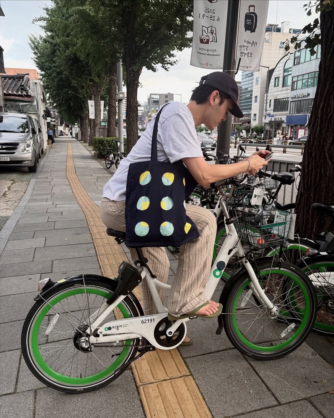 Photo by Euisun Sim 심의선 on July 27, 2025. May be an image of 1 person, bicycle, scooter, street and text.