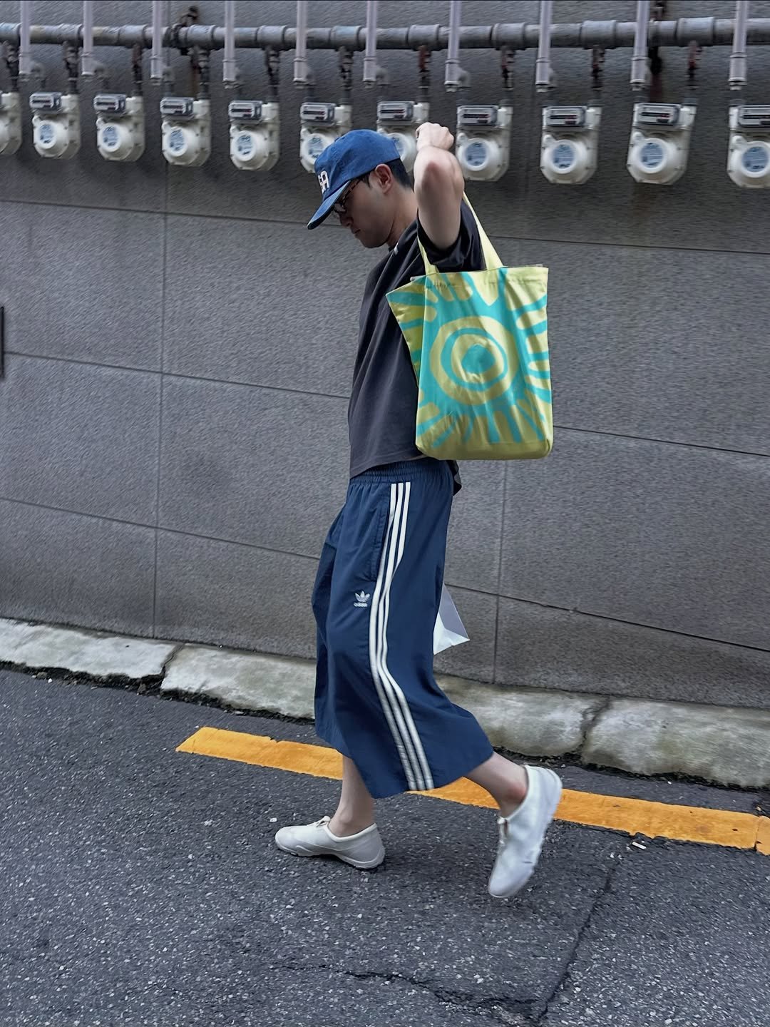Photo by Euisun Sim 심의선 on July 30, 2025. May be an image of 1 person, parking meter, grocery bag, sweatpants, street and text.
