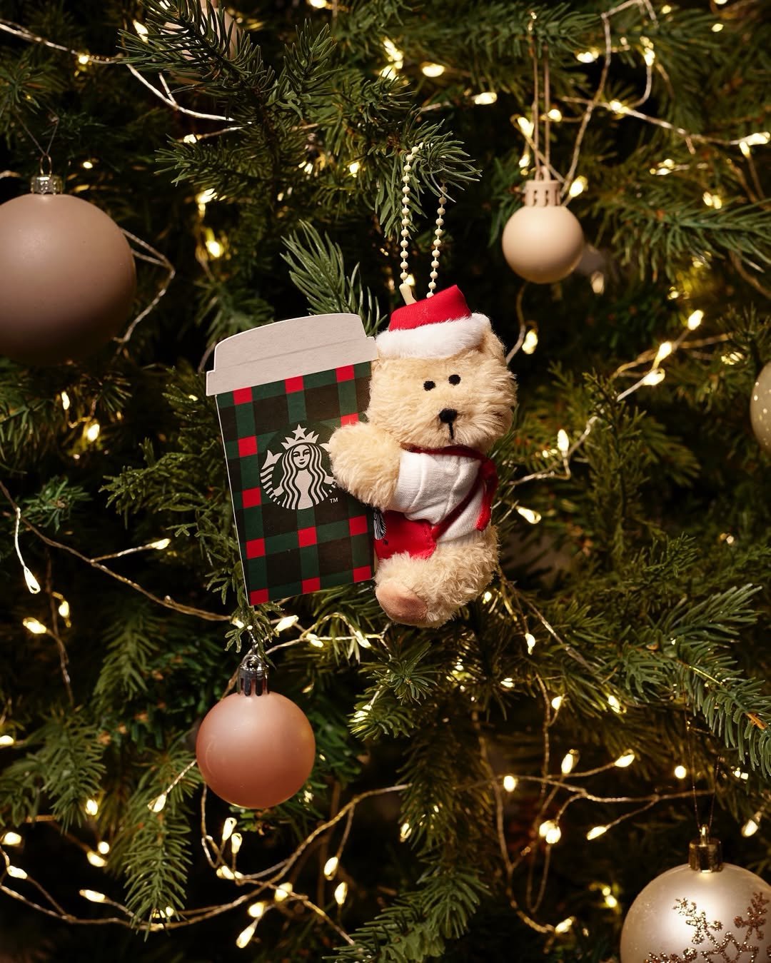 Photo by 스타벅스 코리아 on December 07, 2025. May be an image of bear, christmas tree, tinsel and text.