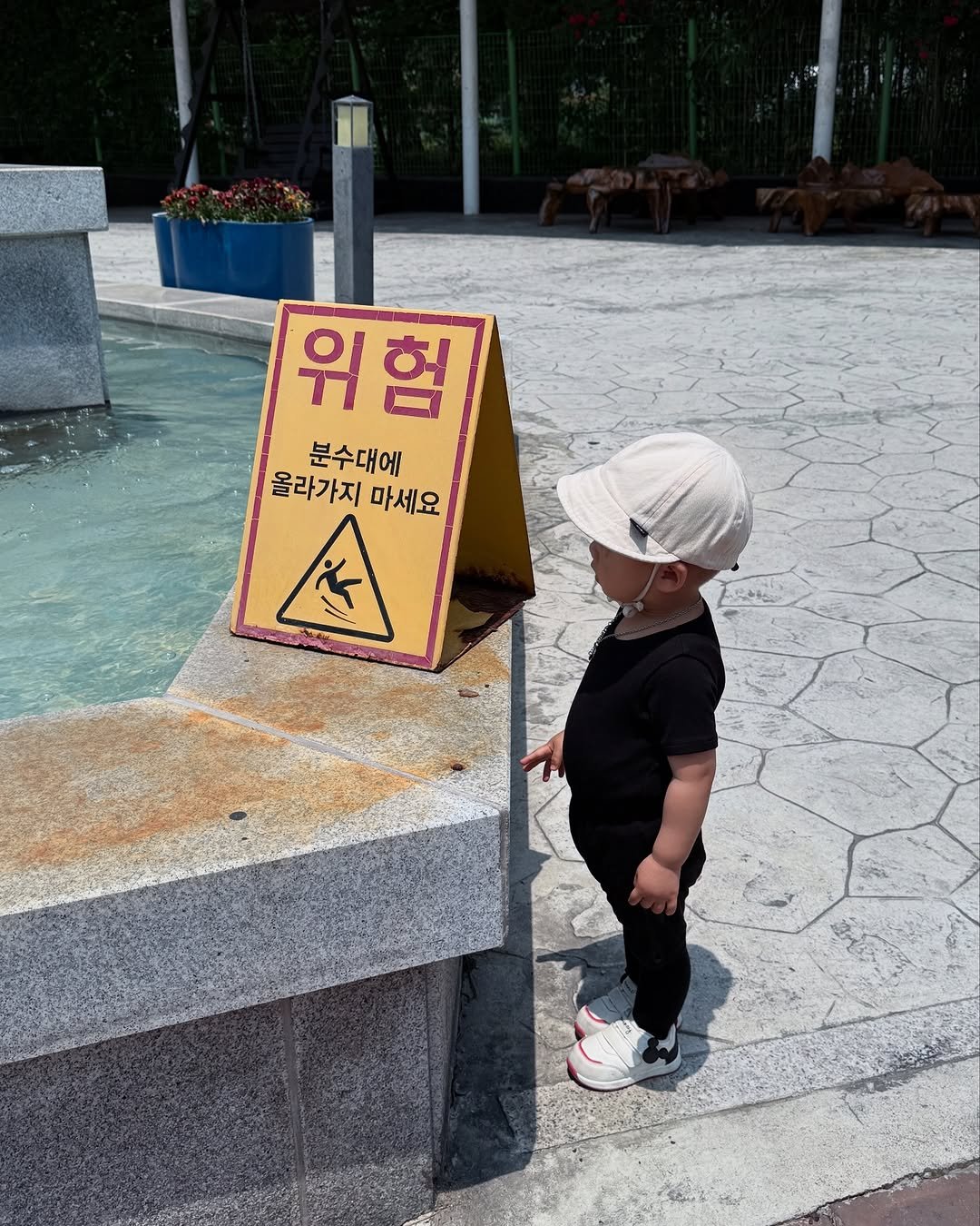 Photo by 양지영 (토빵이네🐰) on June 08, 2025. May be an image of 1 person, baby, standing, hat, baby shoes and text that says '위 위험 험 분수대에 올라가지마세요 올라가지 마세요 本'.