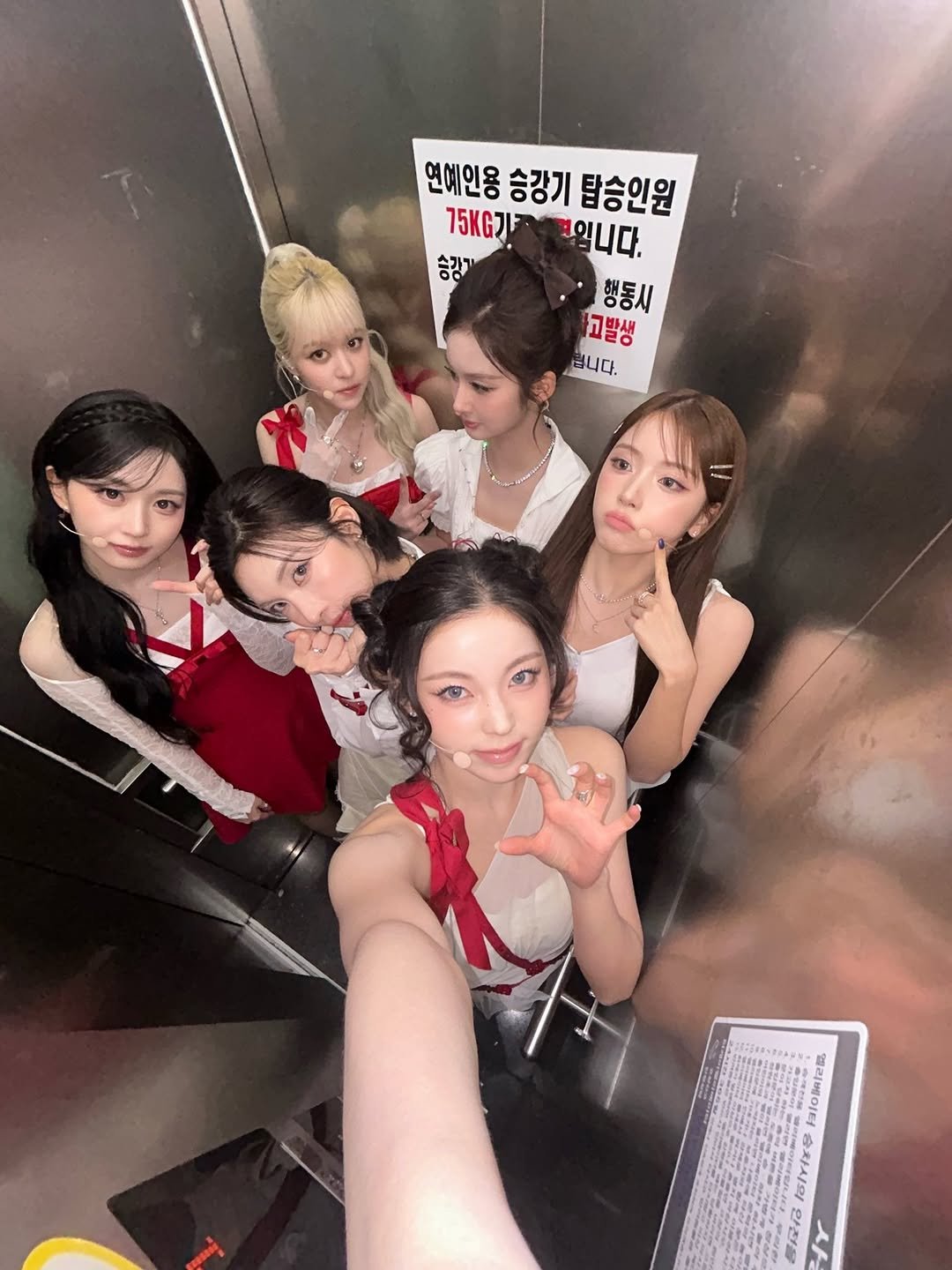 Photo shared by NMIXX KYUJIN (장규진) on February 22, 2026 tagging @nmixx__ohhaewon, @nmixx_kyujin, @jiwoo_nmixx, @sullyoon_nmixx, @bae__nmixx, and @lily_nmixx. May be an image of text that says '연예인용 승강기 탑승인원 75KG 익니다. 승강기 행동시 고발생 됩니다. 三 밸리베이터승치시의 메리베이터 승차시의 인전출 사'.