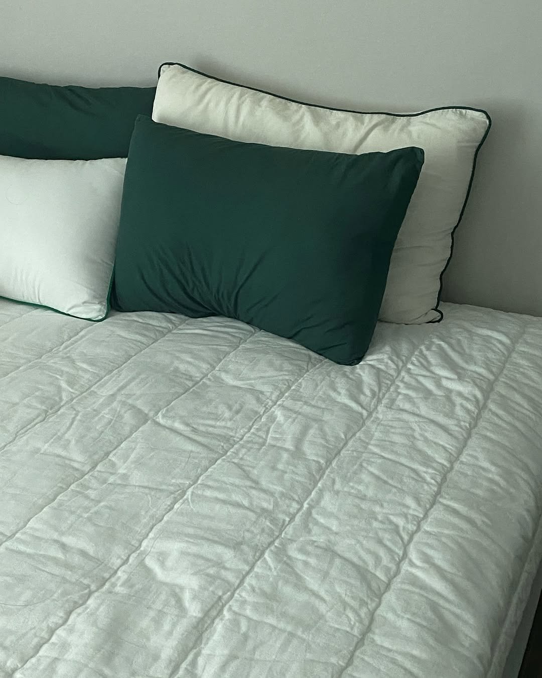 물결 손누빔의 누비패드와 초록색의
베개들