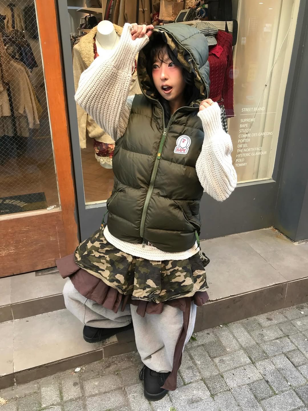 Photo shared by 스윙잉서울 대구 on December 03, 2025 tagging @bape_japan. May be an image of duffle coat, goosedown coat, fur coat, jacket, military uniform, kilt, vest, beret, parka and text.