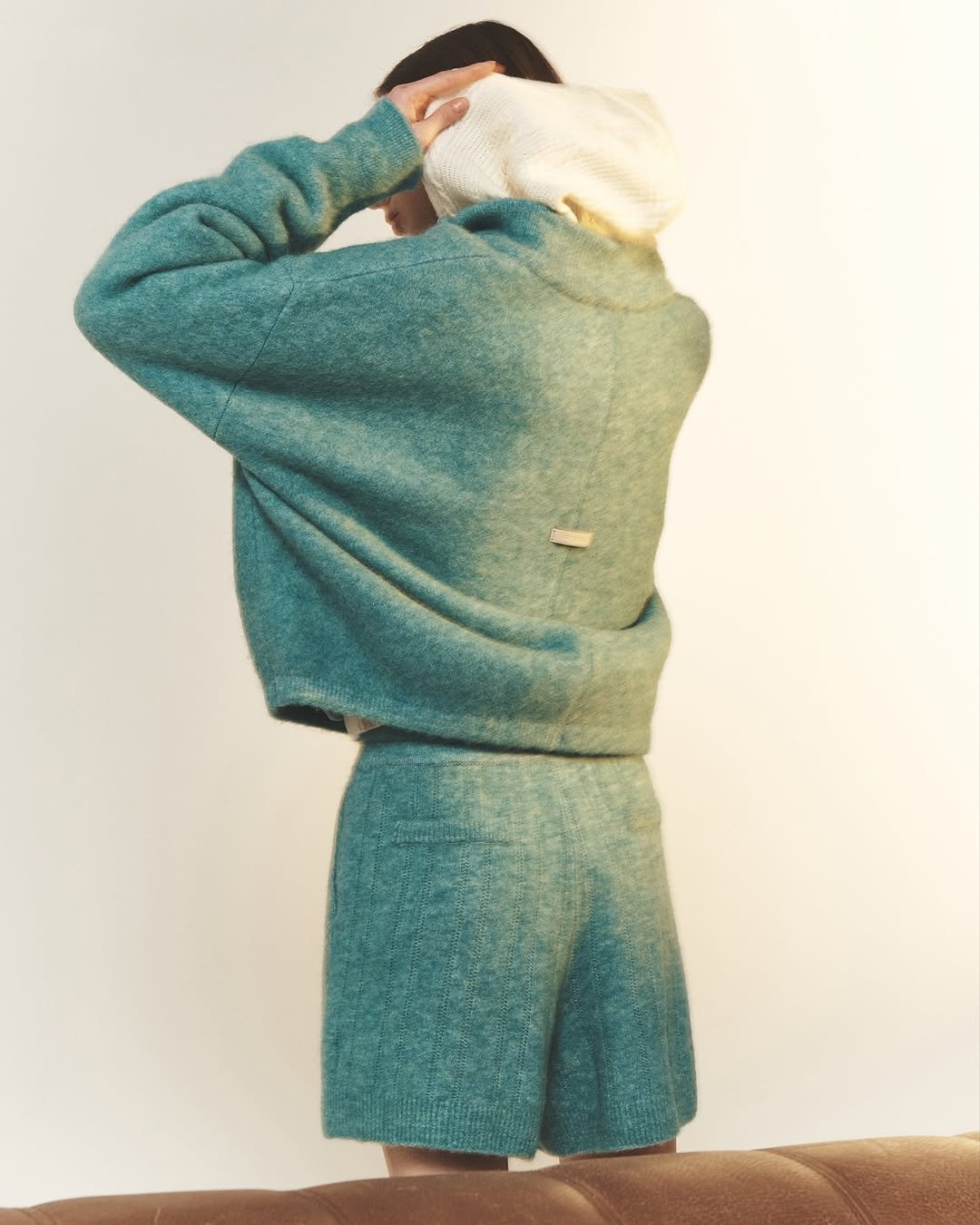 Photo by SYSTEM, SYSTEM HOMME on November 25, 2025. May be an image of duffle coat, sweatpants, sweatsuit, knit, wool, sweater, fleece and text.