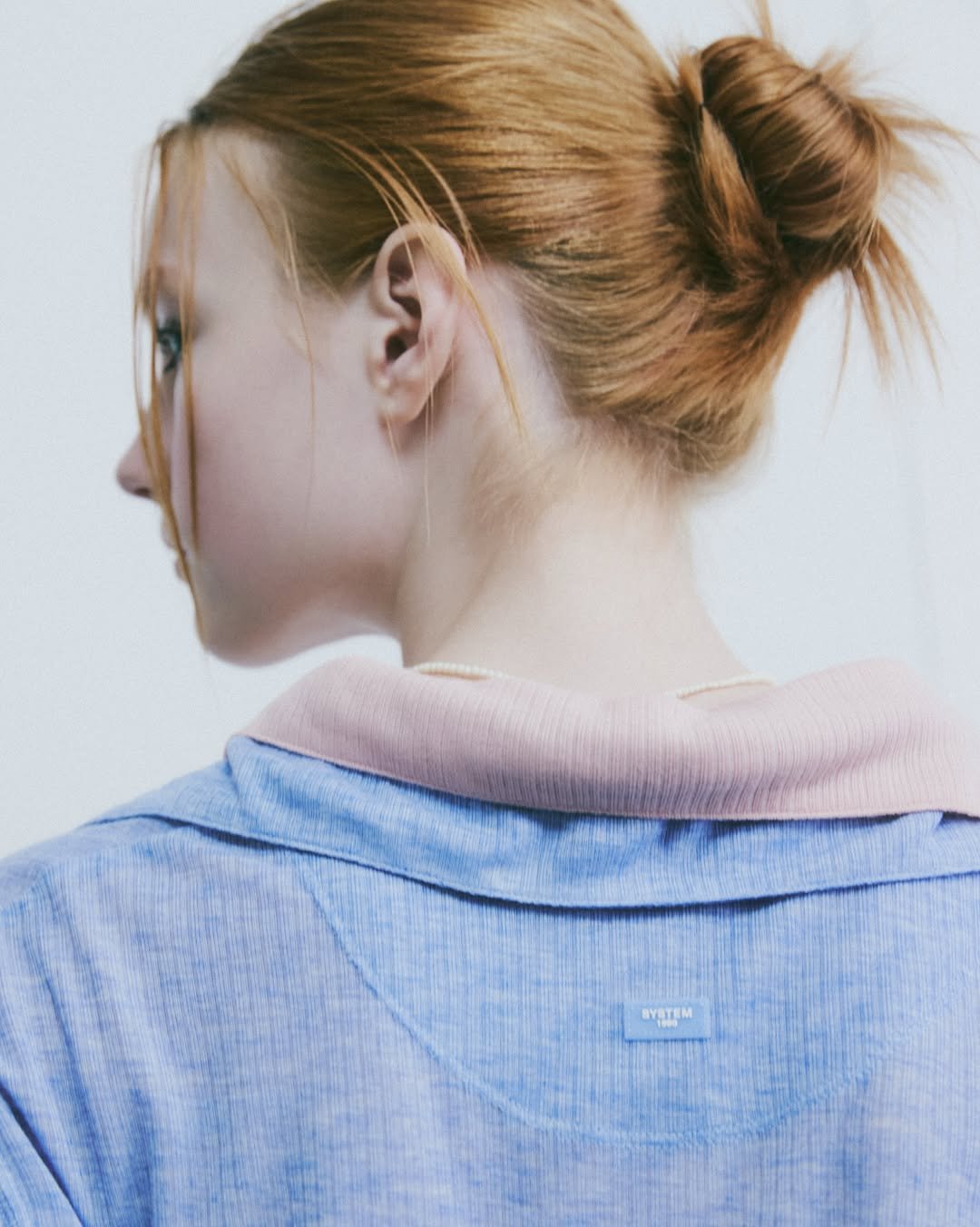 Photo by SYSTEM, SYSTEM HOMME on September 04, 2025. May be an image of 1 person, makeup, hair, turtleneck and text.