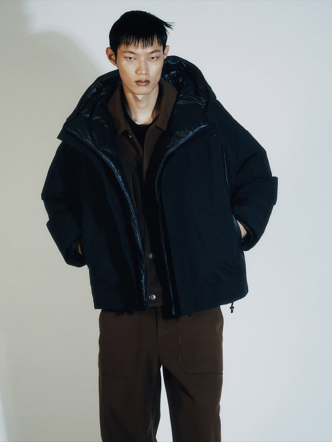 Photo by SYSTEM, SYSTEM HOMME on October 24, 2025. May be an image of overcoat, goosedown coat, duffle coat, jacket, parka and text.