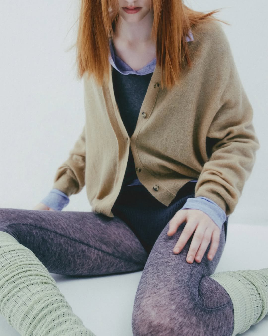 Photo by SYSTEM, SYSTEM HOMME on September 04, 2025. May be an image of 1 person, makeup, sleepwear, sweater, knit, turtleneck, cardigan, fleece, tights and text.