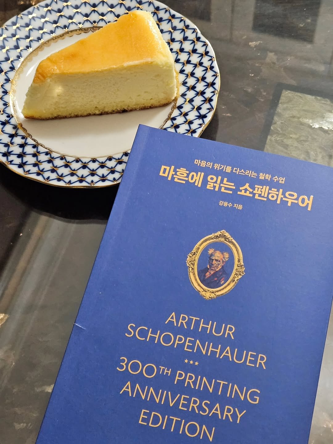 Photo by 취미부자 테소로의 독서기록 on December 16, 2025. May be an image of chiffon cake, book, cheesecake and text that says '마흔에 마음의 위기를 읽는 다스리는 절학수업 철학 강용수지음 강용수 지음 쇼펜하우어 수업 SCHOPENHAUER SCHOPENHAUER * ARTHUR 300TH TH ANNIVERSARY ANNIVERSARY PRINTING PRINTING EDITION'.