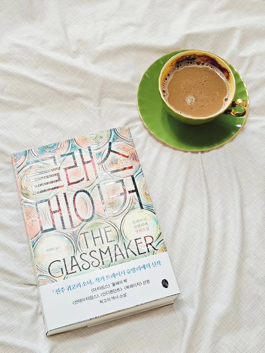 Photo by 취미부자 테소로의 독서기록 on February 09, 2026. May be an image of coffee cup, book and text that says 'ป. 0 슈발리 (THE 트레이사 유발리운 ယို 칼편소설 박력주 박선주음진 진주 GLASSMAKER 커고리소녀 <더 더타입스> '음해의 (복패이지> 선정 귀고리 소녀, 작가 트레이시 슈발리에의 신작 <인디핸던트>, '최고의역사소설' 역사소설' (선데아 선데이타임스> 타임스>, '최고의'.