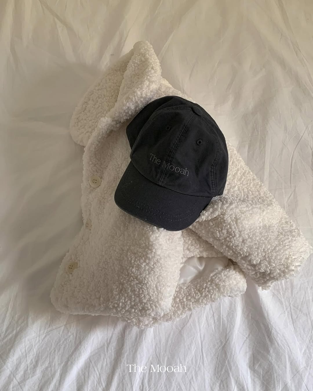 Photo by The Mooah on December 17, 2025. May be an image of duffle coat, hat, blanket, bath robe and text.