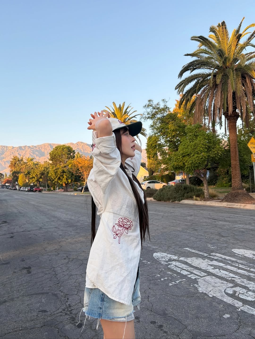 Photo by Wendy on November 05, 2025. May be an image of standing, hat, shorts, miniskirt, headscarf, road, palm trees and text.