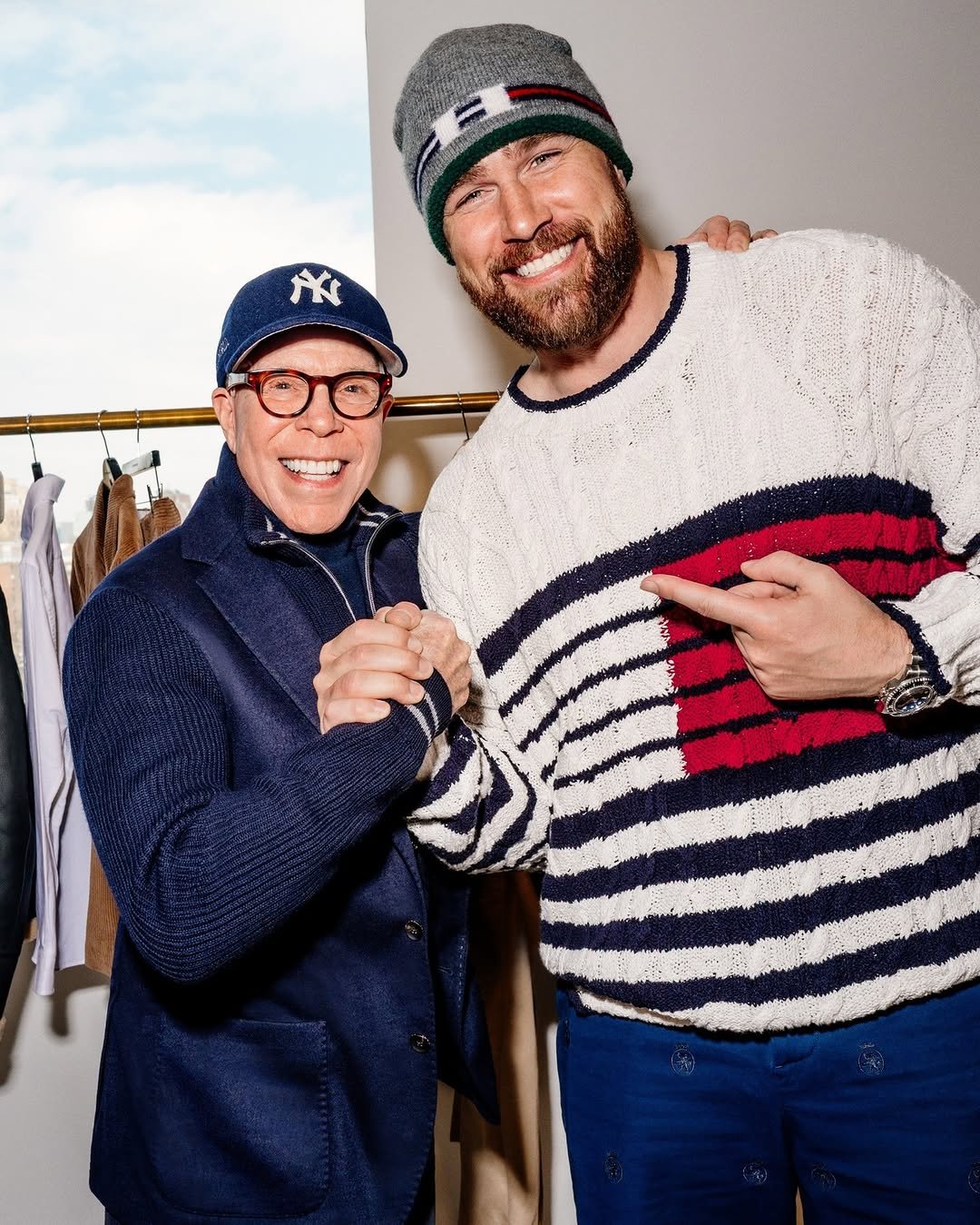 Photo shared by Tommy Hilfiger on March 30, 2026 tagging @killatrav. May be an image of one or more people, beard, hat, eyeglasses, sweater, turtleneck and text.