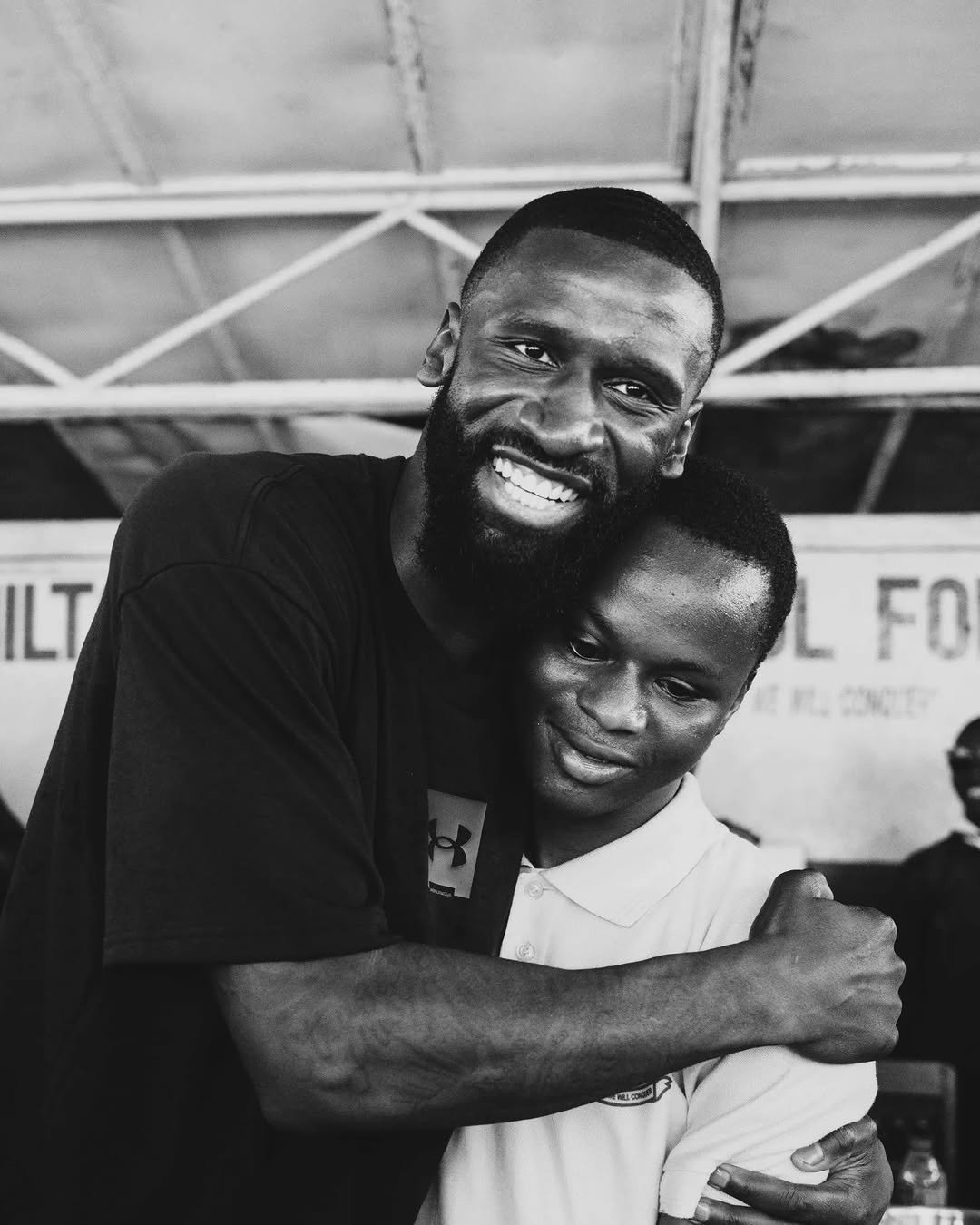 Photo shared by Antonio Rüdiger on January 01, 2026 tagging @antoniorudigerfoundation. May be a black-and-white image of one or more people, beard, child, people smiling and text.