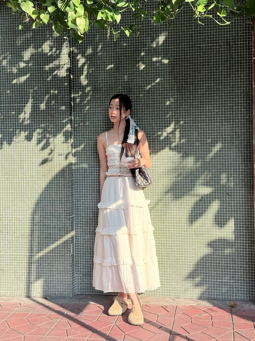 Photo shared by ตู / t u on April 13, 2026 tagging @aeriethailand. May be an image of sundress, brick wall and text.