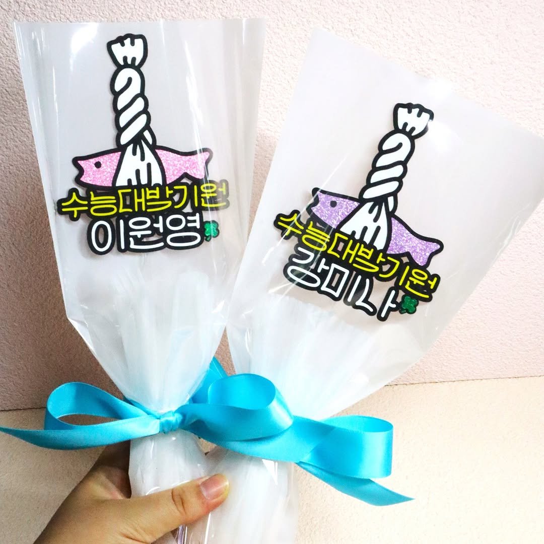 Photo shared by 투머치토퍼 캐리커쳐토퍼 상견례 초경토퍼 궁예토퍼 칠순토퍼 신림토퍼 on March 12, 2026 tagging @ok_ticon. May be an image of ‎lollipop and ‎text that says '‎a 2 수능대박기원 이원영 워역' u E フトロルド 감미나! מוראו, 수능대박기원‎'‎‎.