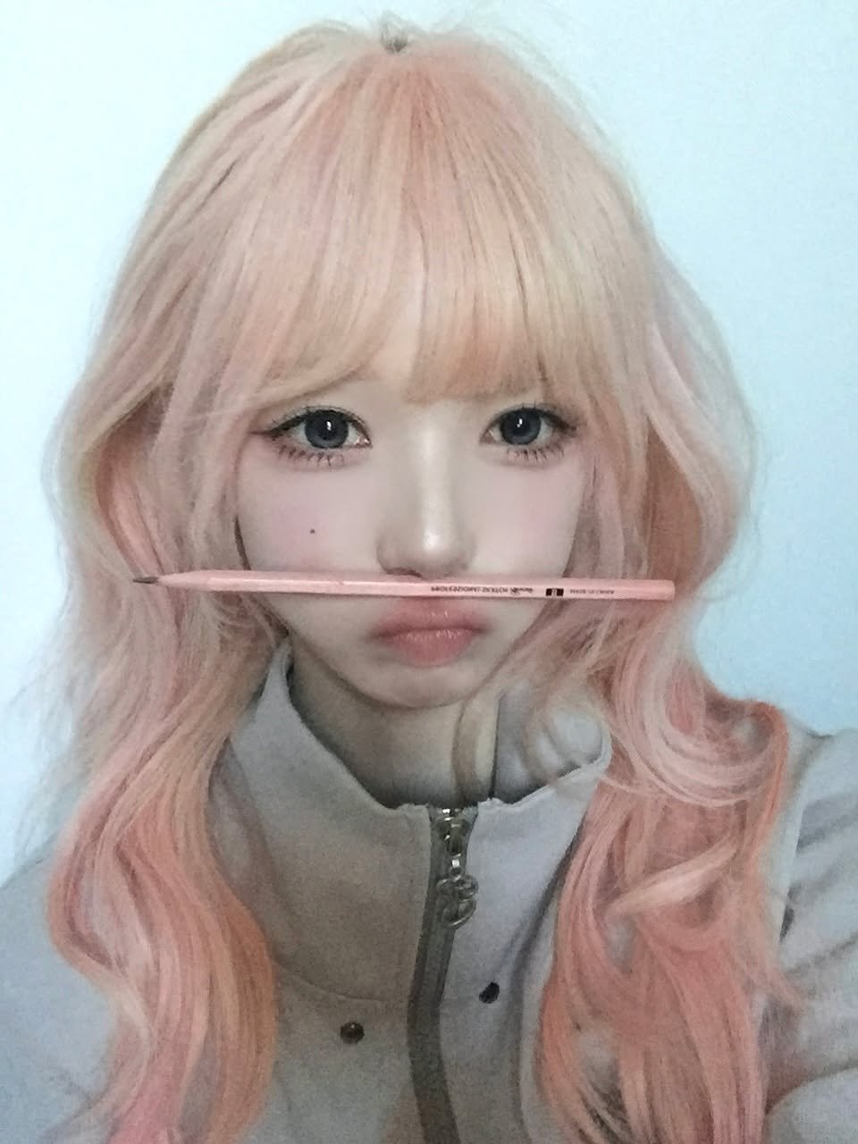 Photo by tripleS official on March 27, 2026. May be an image of one or more people, bangs, blonde hair, makeup, eyeliner, duffle coat and text.