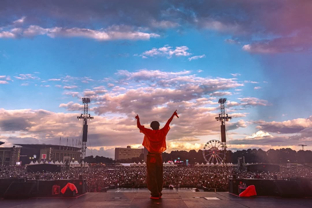 Photo shared by jhope on July 14, 2025 tagging @lollapaloozade. May be an image of 1 person, crowd, cloud, concert and text.