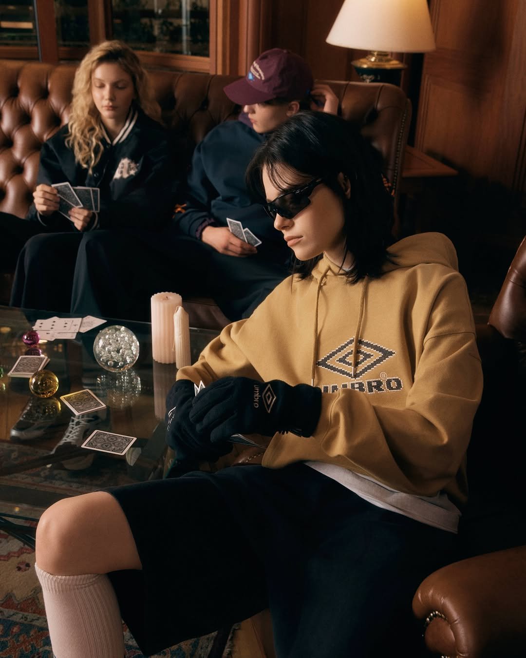 Photo by 엄브로 코리아 on February 24, 2026. May be an image of one or more people, makeup, eyewear, duffle coat, bolo tie, magazine, turtleneck and text.