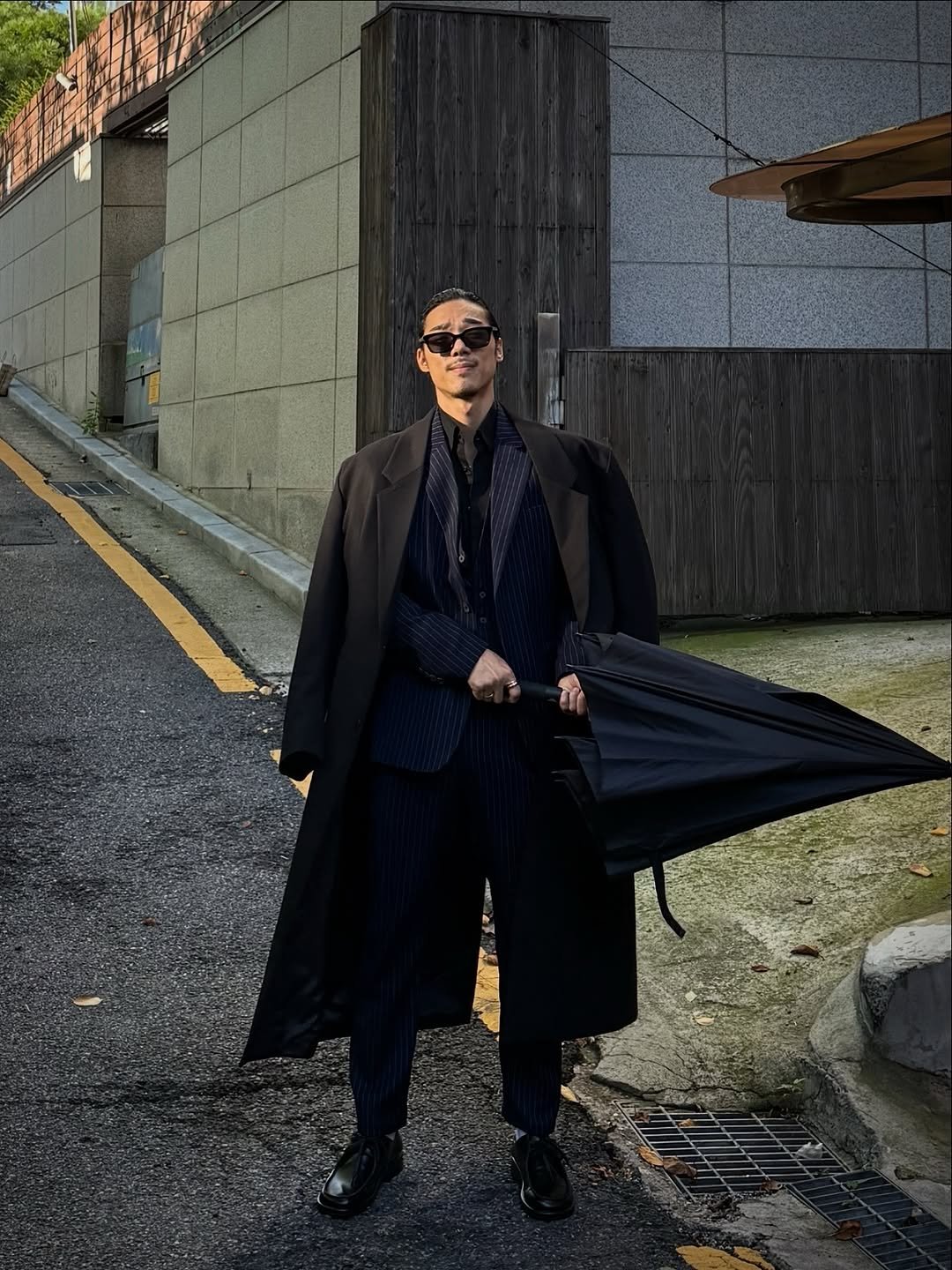 Photo by 비 르 on September 24, 2025. May be an image of 1 person, duffle coat, overcoat, bowler hat, cloak, umbrella and text.