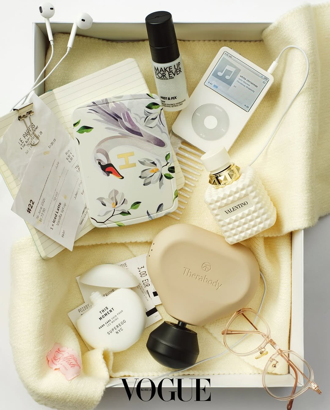Photo by VOGUE KOREA on December 01, 2025. May be an image of fragrance, digital audio player, phone, lotion, pouch, bar soap, perfume, portable cassette player, hand cream and text.
