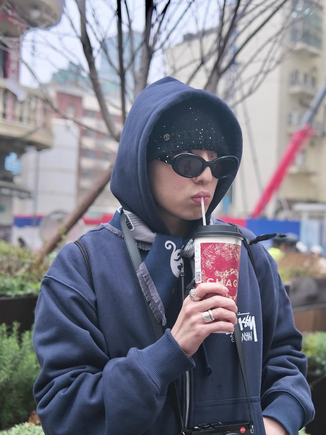 Photo by 강승윤 KANGSEUNGYOON on March 29, 2026. May be an image of duffle coat, phone, cigarette, parka, face mask and text that says 'CL CLAG AG'.