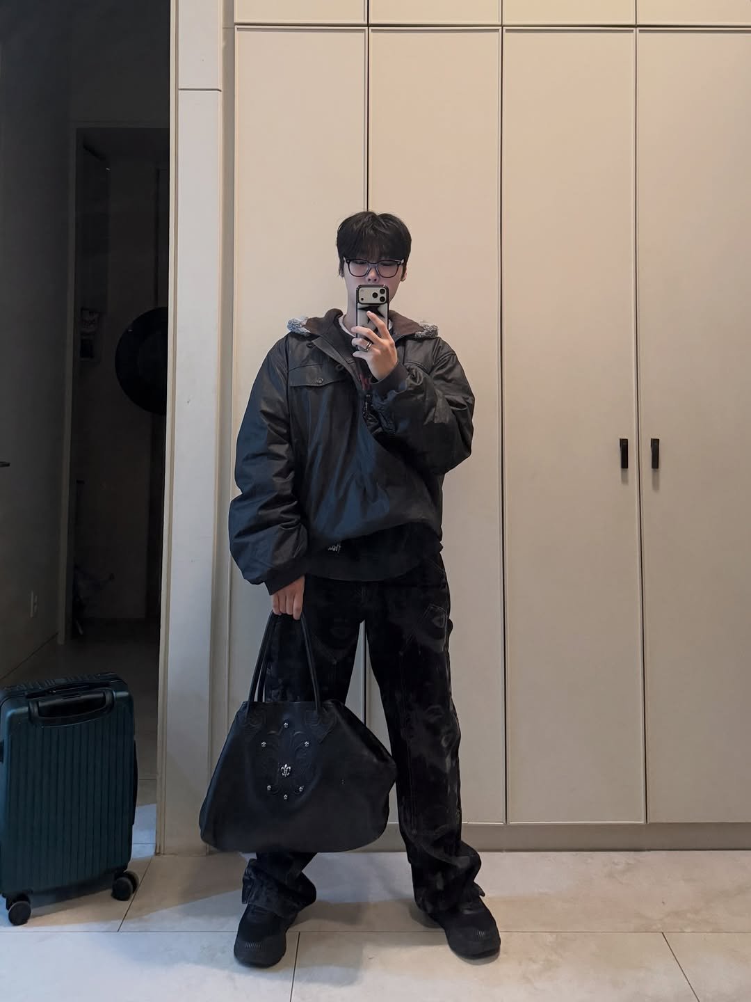 Photo by 내일 on March 17, 2026. May be an image of overcoat, suitcase, wingtip shoes, duffle coat, parka, sweatpants and text.