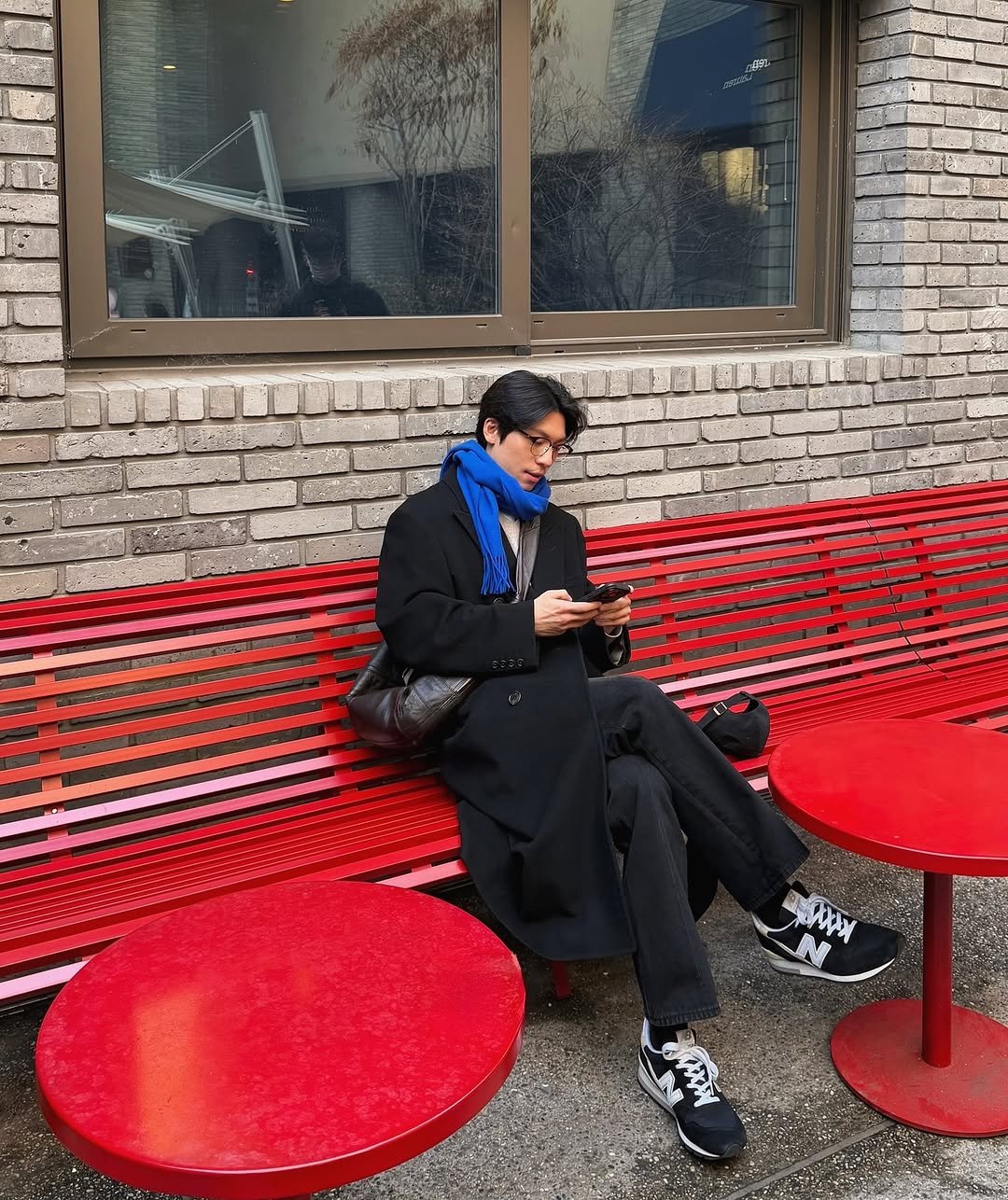 Photo by 위하준 Wi Ha Jun on December 27, 2025. May be an image of duffle coat, overcoat, phone, wingtip shoes, parka, bench and text.