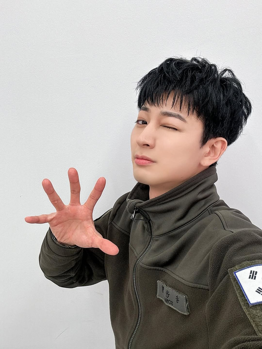 Photo by iKON(아이콘) GET READY, SHOWTIME! on February 12, 2026. May be an image of one or more people, bangs, parka, military uniform, top and text that says 'HH S'.