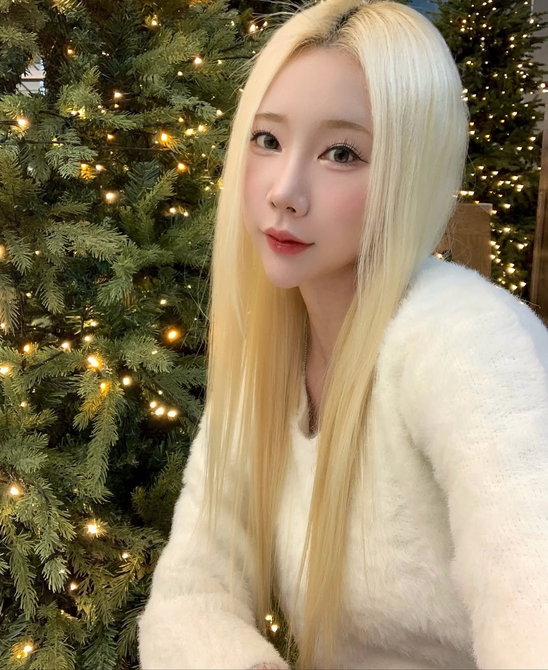 Photo shared by 예린 on November 23, 2025 tagging @glphyo. May be a selfie of one or more people, blonde hair, christmas tree, outdoors and text.