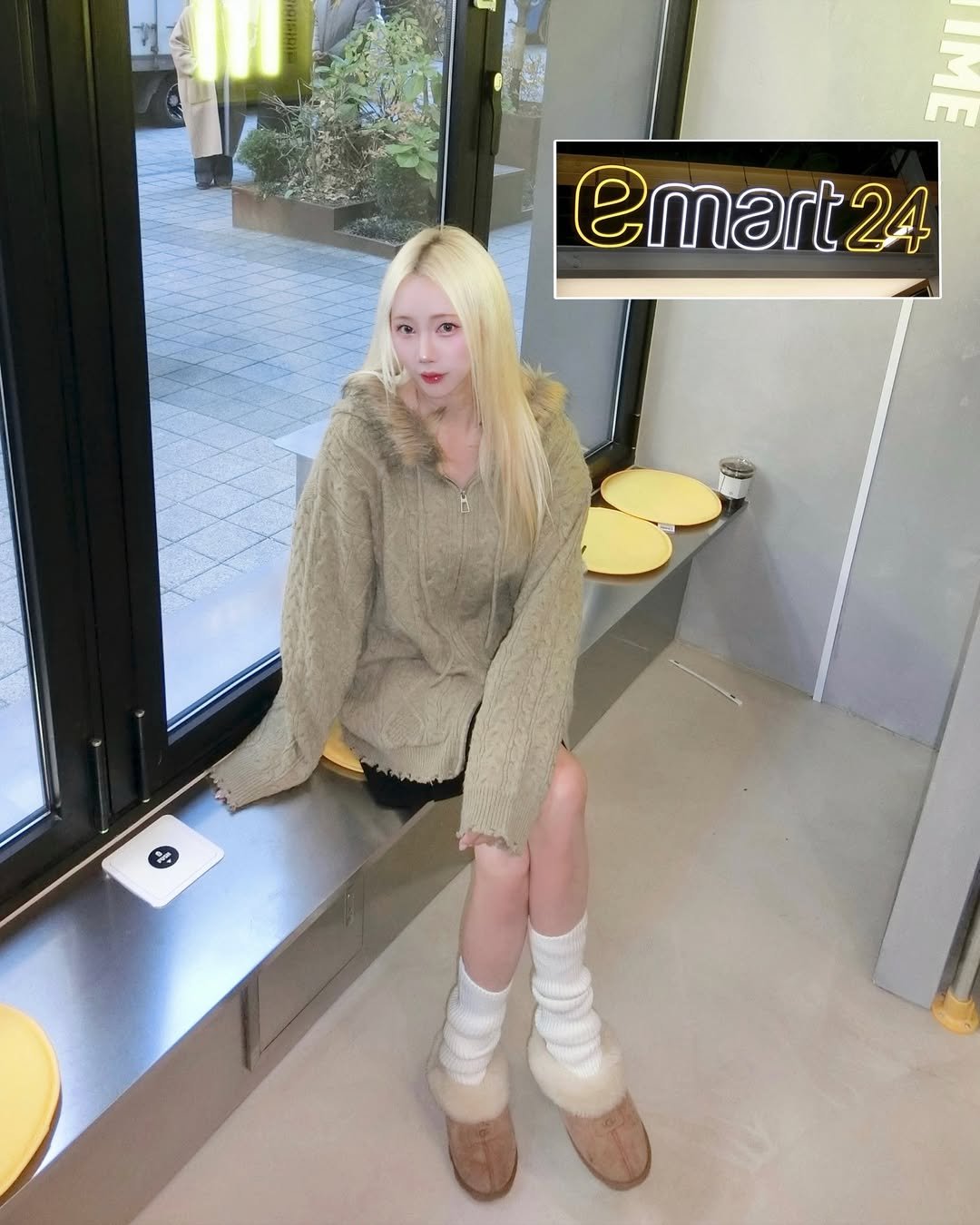 Photo shared by 예린 on December 01, 2025 tagging @emart24_official, and @badblue_badblue. May be an image of one or more people, blonde hair, duffle coat, goosedown coat, fur coat, miniskirt, boots, top, parka and text.