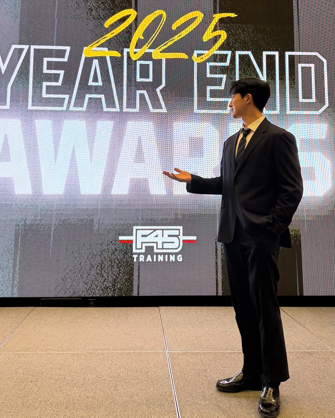 Photo shared by 민규 on December 31, 2025 tagging @f45_training_korea, and @leo._.leyo. May be an image of one or more people, people standing, suit, dinner jacket, magazine, blazer, newsroom and text that says 'EAR EAREN TENO END F45- TRAINING'.