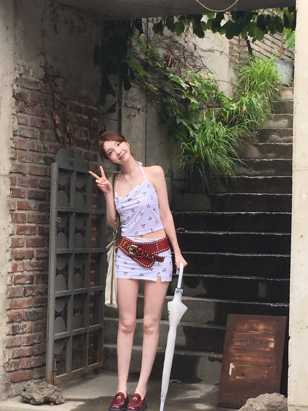 Photo by xöoos 수스 on July 19, 2025. May be an image of 1 person, parasol, shorts, sword, brick wall and text.