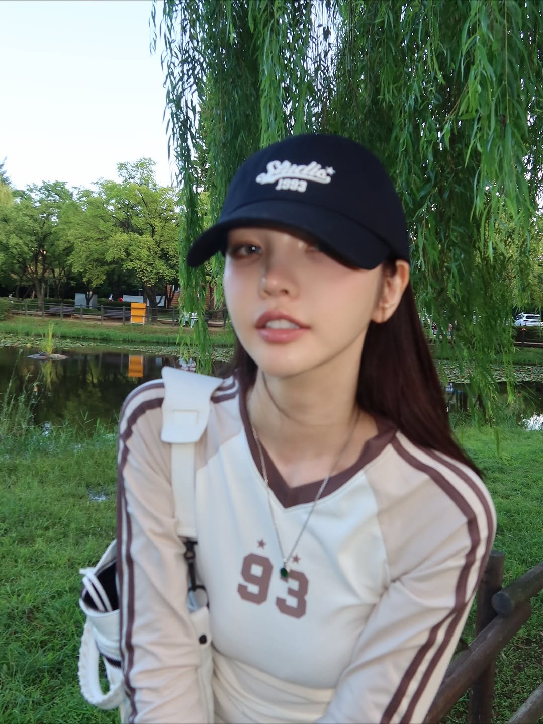 Photo shared by xöoos 수스 on September 23, 2025 tagging @1993studio_official. May be an image of 1 person, hat, sportswear, top, outdoors and text.