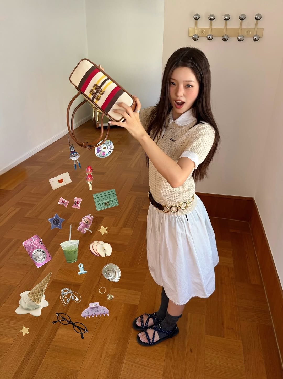 Photo shared by 해삐 on July 15, 2025 tagging @miumiu. May be an image of 1 person, wind chime, basket, tambourine and text.