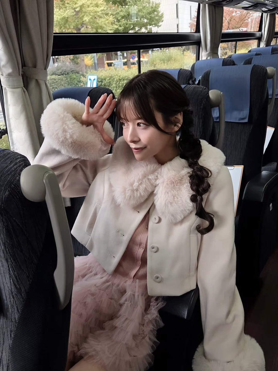 Photo by 八木奈々 on November 16, 2025. May be an image of one or more people, hair, duffle coat, overcoat, fur coat, parka, bus and text.